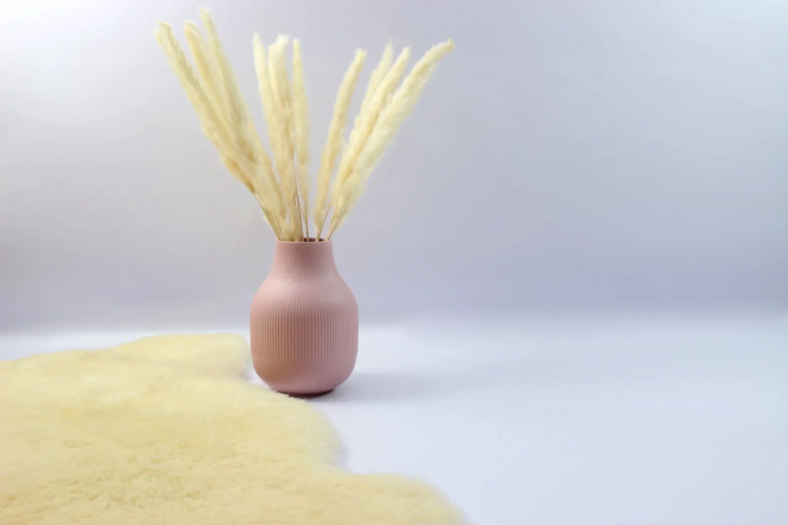 Pink ceramic vase with dried grass